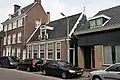 Huis met recht opzij een houten topgevel en in de onderpui een deurkalf met anno 1700