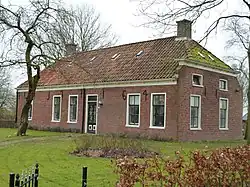 Pand onder pannen wolfsdak met hoekschoorstenen en met achtergevel met middeleeuwse kloostermoppen