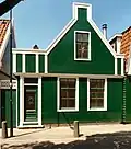 Houten huis met aan de straat een puntgevel met zijpilasters