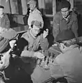 Wachtend op een opdracht spelen Finse dokwerkers een partijtje (1958).