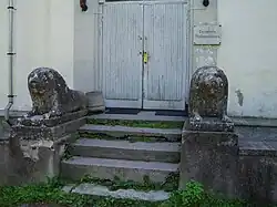 Leeuwen bij de ingang. De tekst op het bordje: ‘Gemeentehuis van Laimjala’