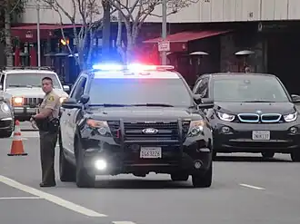 Een hulpsheriff van de LASD naast zijn dienstauto