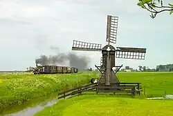 Tijdens het bezoek van stoomlocomotief LB&SCR 672 'Fenchurch' van de Bluebell Railway werd de samenwerkingsovereenkomst tussen beide organisaties bekrachtigd. De loc rijdt langs de Broerdijk ter hoogte van de Klikjesmolen, 20 mei 2002. Foto: Rob Veninga.