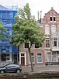 Woonhuis in sobere traditionele trant, bestaande uit parterre, verdieping en zolderverdieping in het met pannen gedekte schilddak waarvan de nok dwars op de straatas staat