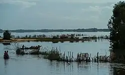 Vissers in prauwen (pirogues) varen langs fuiken aan de zuidrand van het Alanampotsymeer