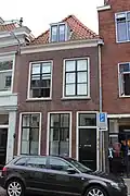 Huis bestaande uit twee bouwlagen, een kap loodrecht op de straat en een kelder onder het achterste deel