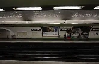 Een man strikt zijn veters op het perron richting Bobigny