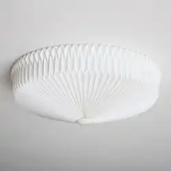Foto van een plafondlamp van gevouwen papier. De foto van de lamp is genomen tegen een witte achtergrond.