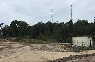 Leersumse Berg (zuidzijde) met op de top twee telecommunicatiezendmasten. Op de voorgrond wordt de woningbouwlocatie 'Hoog Leersum' bouwrijp gemaakt.