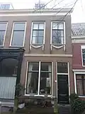 Pand met gevel met rechte kroonlijst en pilasters. De gevel vormt een geheel met nr 42. Guirlandes onder de ramen