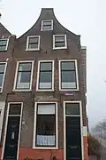 Pand met tuitgevel, gepleisterde zijgevel aan de Oranjegracht. Opkamer en onderhuis