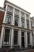 Pand met pilastergevel, beneden vijf Ionische pilasters, daarboven Korinthische