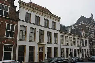 Pand met gepleisterde brede gevel met rechte kroonlijst