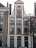 Pand met statige halsgevel met zandstenen versieringen, zandstenen vleugelstukken en segmentfrontons. Boven topvenster gebeeldhouwd wapen. Hardstenen stoep en hekwerk, gebouwd voor Prof. Franciscus de le Boë Sylvius, hoogleraar in de geneeskunde. Stadhuis van Prof. Boerhaave