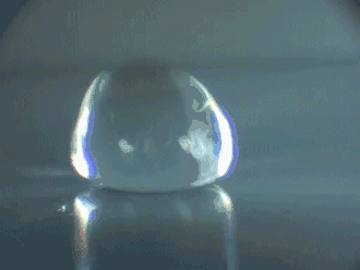 Animatie: Een druppel stuitert op een hete plaat, kennelijk net onder het leidenfrost-punt