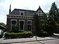 Dit woonhuis is volgens een hardstenen opzetstuk op de gevel gebouwd in 1917 onder invloed van de neorenaissance en bestaat uit een begane grond en een zolderverdieping.