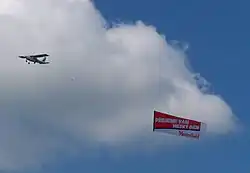 Slepen van een spandoek met een reclameslogan