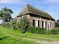 Boerderij waarvan het met een rieten schilddak gedekte woonhuis dwars op de stal is gebouwd