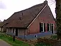 Boerderij met zijbaander en gedeeltelijk met riet bedekte puntgevel