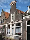 Huis voorzien van een klokgevel met fronton