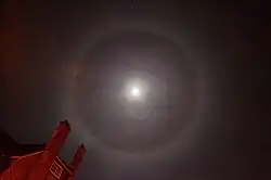 Een 22°-halo om de maan. Let op het subtiele kleurverloop van roodachtig aan de binnenzijde naar blauwig aan de buitenzijde.