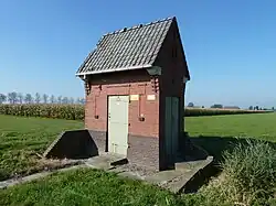 Het transformatorgebouwtje naast de westelijkste boerderij is een rijksmonument