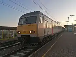 Zonsondergang en trein richting Brussel op het station