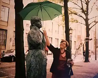 Maïté Duval in 2003 te Den Haag met paraplu bij haar beeld Paula in Kamerjas