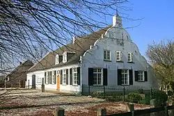 Huis waarvan de voorgevel een top met uitgezwenkte trappen heeft