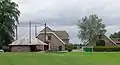 Dwarshuisboerderij met schuur, hooiberg, bakhuisje en eikenlaan