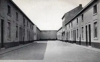 Het noordelijk straatje in Quartier Amélie, gezien naar het westen en doodlopend op een fabrieksmuur. Het hogere pand rechts lag in de as van de "hoofdstraat"