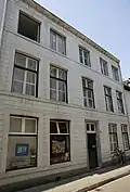 Huis met brede gepleisterde lijstgevel.