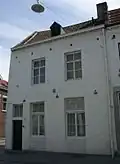 Huis met lijstgevel, met banden en hoekblokken.