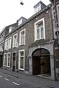 Huis met brede lijstgevel en een koetspoort.