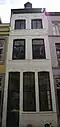 Huis met lijstgevel, voorzien van vensters in segmentboogomlijstingen van Naamse steen en onderbroken verticale reliefbanden.