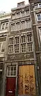 Huis met smalle lijstgevel, voorzien van vensters in Naamse steen, horizontale reliefbanden en profiellijsten, gevelsteen 17 06.