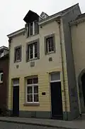 Huis met lijstgevel; de verdieping met een venster in Naamse steen, geflankeerd door twee kleinere. Gevelstenen met 17 52.