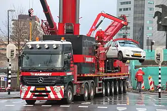 Mammoet tilt een eigen auto op een vrachtwagen