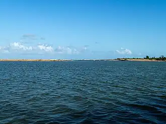 Monding van de Mangoro in de Indische Oceaan gezien vanaf het Canal des Pangalanes. Op de achtergrond de branding van de oceaan.