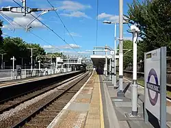 Sporen en perrons in de huisstijl van de Elizabeth line, rechts het goederenspoor.