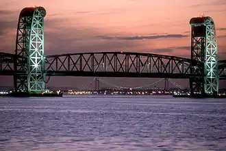 De Marine Parkway-Gil Hodges Memorial Bridge verlicht 's avonds met achterliggend de lichten van Coney Island en de Verrazano-Narrows Bridge in 2012