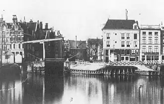 Open Havenfront en Prins Hendrikkade 25-29. In het midden de Oude Haarlemmersluis en daarachter de Martelaarsgracht. 19e-eeuwse foto.