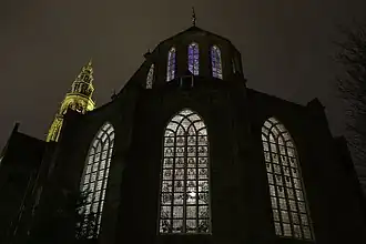 Close-up van de buitenzijde van het koor met gebrandschilderde ramen bij avond