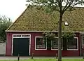 Woonhuis en werkplaats onder een dak. Gevel van woning vernieuwd. Woonhuis zou de woning van de molenmaker van de "Vijf Noorderkoggen" zijn