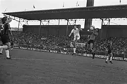 Eddy van der Roer heeft de bal klemvast, voordat Geert Meijer gevaarlijk kan worden