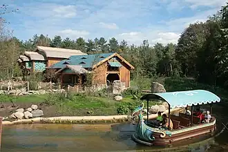 Stationsgebouw met passerende boot.