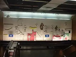 Sculpturen van Marc Mendelson boven de roltrappen.