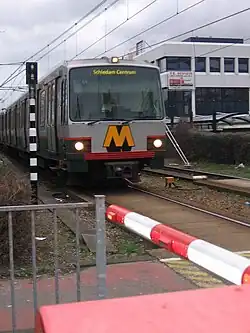 Metro passeert spoorwegovergang naast station Alexander
