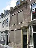 Huis met rechte gevel en gootlijst op klosjes