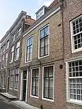 Huis met geverfde lijstgevel, boven de pui overkragend